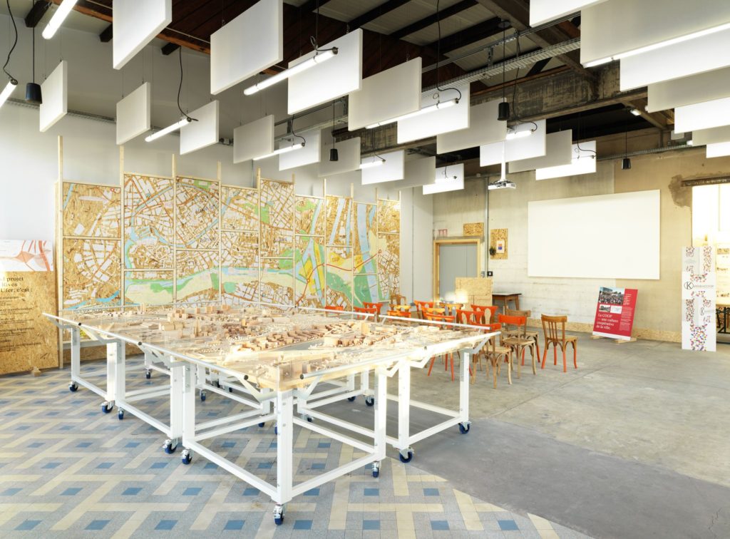 Point Coop – Café Deux-Rives exhibition space, with its interactive display wall and project model. Photo credit: Siméon Levaillant