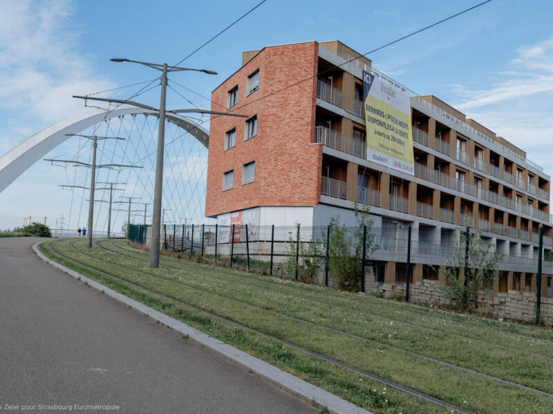 Quai Ouest, vue depuis l'arrêt de tram Citadelle. Un bâtimroment de 7 étages en briues adossé au talus du tram avec le pont en deuxième pla,