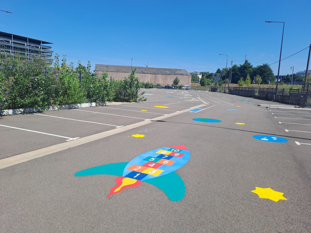 Peintures au sol pour transformer le parking provisoire en espace de jeu