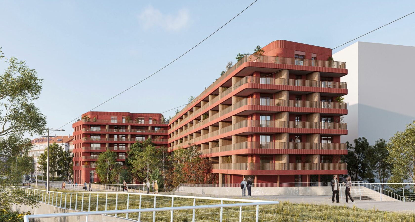 Un bâtiment de 6 étages, rouge avec des loggias bordées de balcons filants incurvés aux angles.