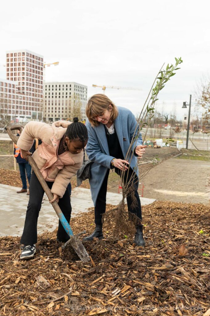 Un enfant de l'école du Rhin en train de planter un arbuste avec une adulte