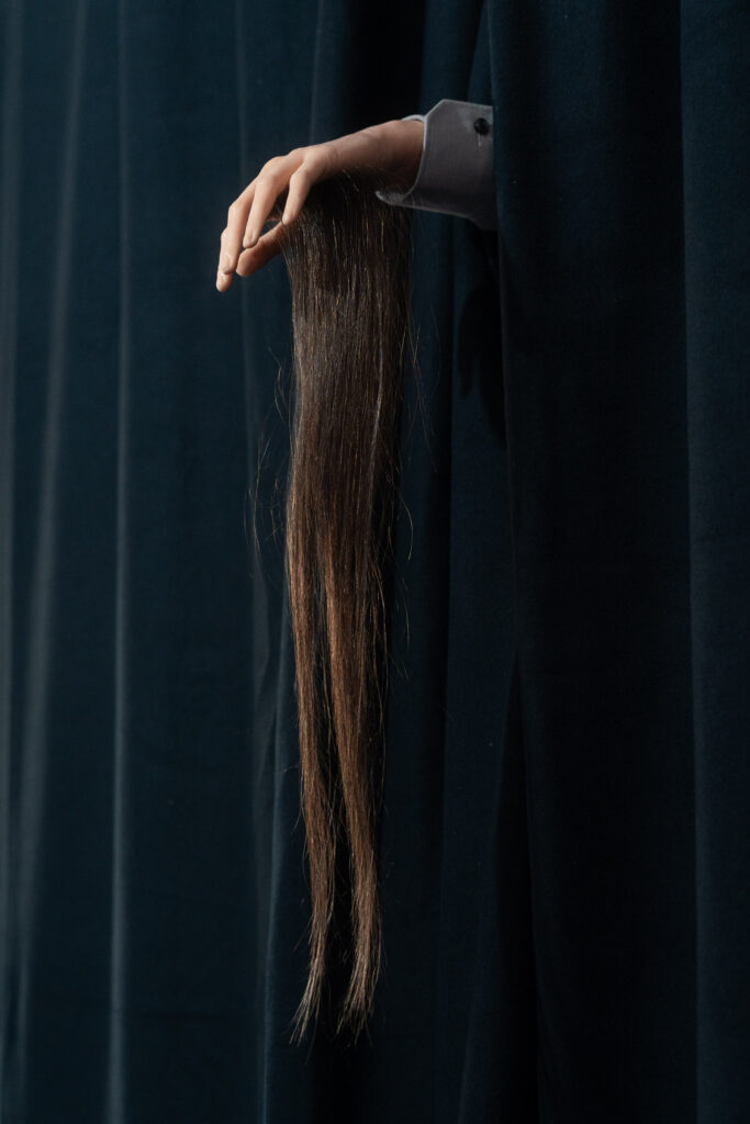 Une main de mannequin sort d'un rideau de théâtre noir : une installation de Svenja Gansner dans le cadre de la Regionale 26 à Garage Coop